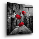 Drei Schwebende Rote Regenschirme in Regnerischer Gasse Glasbild - 40x40 cm