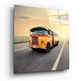 Vintage Orangener Bus auf Sonnenuntergangsstraße Glasbild - 40x40 cm