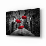 Drei Rote Regenschirme in Regnerischer Gasse Glasbild - 72x46 cm